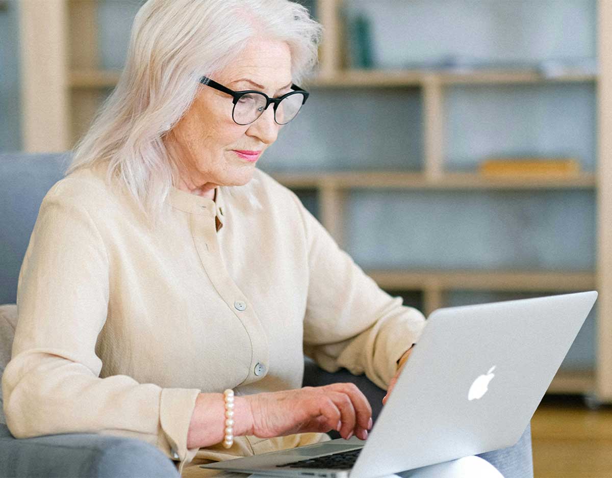 Older Woman Using Laptop On A Sofa
